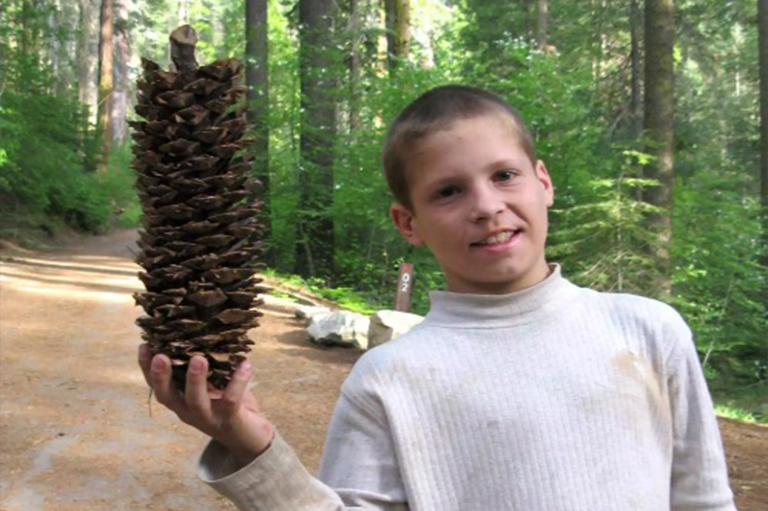 男孩舉起大糖松果.jpg 男孩舉起大糖松果